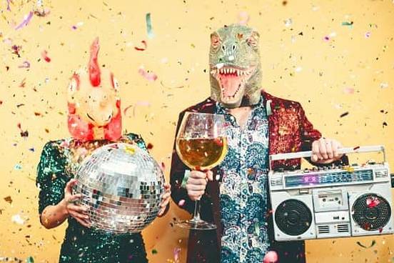 couple wearing chicken and dinosaur heads partying with boombox and disco ball